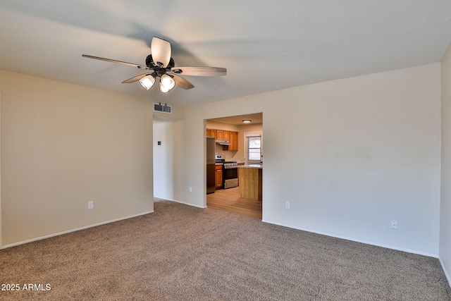 carpeted spare room featuring ceiling fan