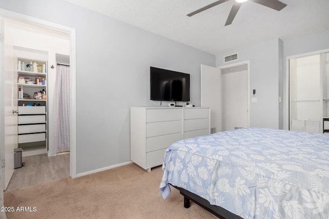 bedroom with baseboards, visible vents, ceiling fan, and light colored carpet