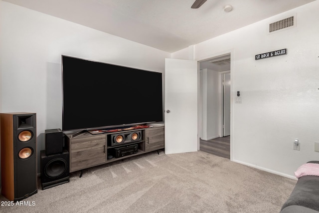 carpeted living area featuring visible vents and a ceiling fan