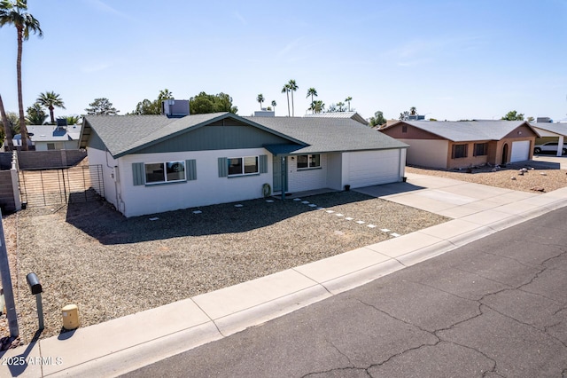 ranch-style house featuring central AC, fence, concrete driveway, and roof with shingles