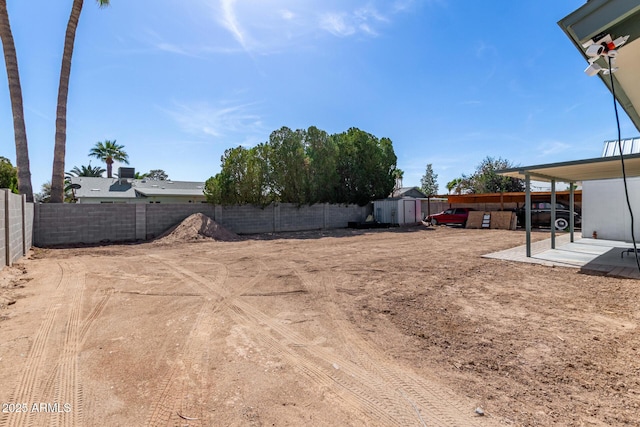 view of yard featuring a storage shed, a patio area, an outdoor structure, and a fenced backyard