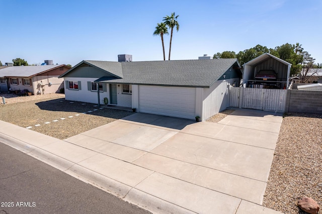 ranch-style house featuring an attached garage, a shingled roof, fence, driveway, and a gate