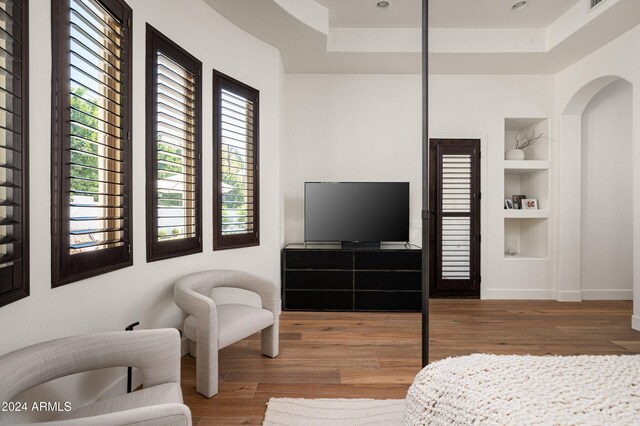 bedroom featuring wood-type flooring and a raised ceiling