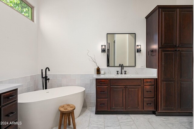 bathroom featuring tile walls, vanity, and a tub