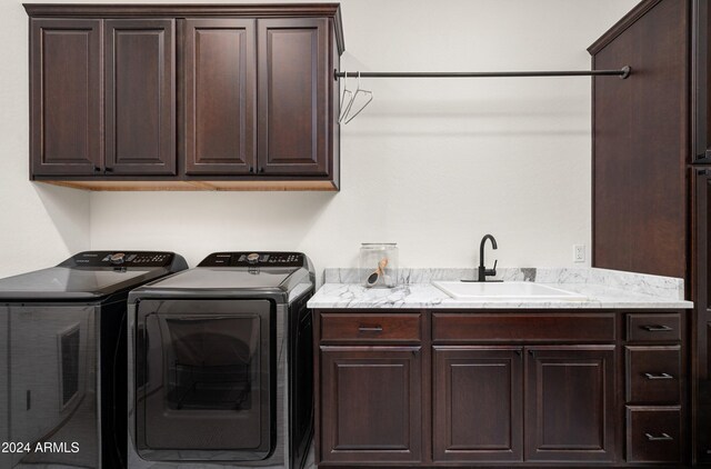 laundry room with independent washer and dryer, cabinets, and sink