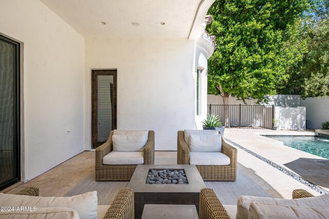 view of patio / terrace featuring a fenced in pool and an outdoor living space with a fire pit