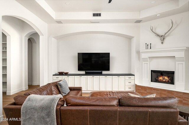 living room with wood-type flooring and a tray ceiling