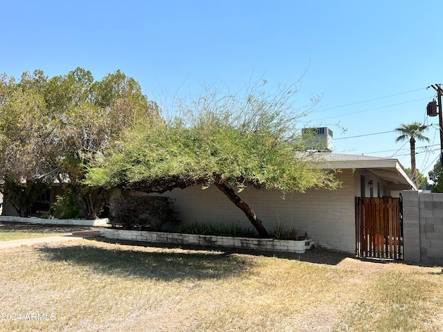 view of side of home featuring a yard and central AC unit