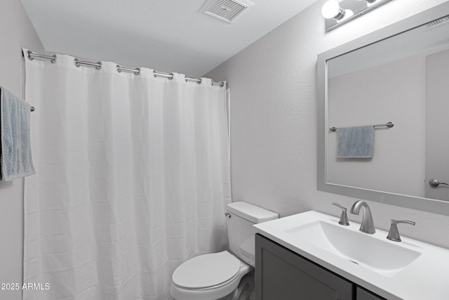 bathroom featuring a textured ceiling, a shower with curtain, vanity, and toilet