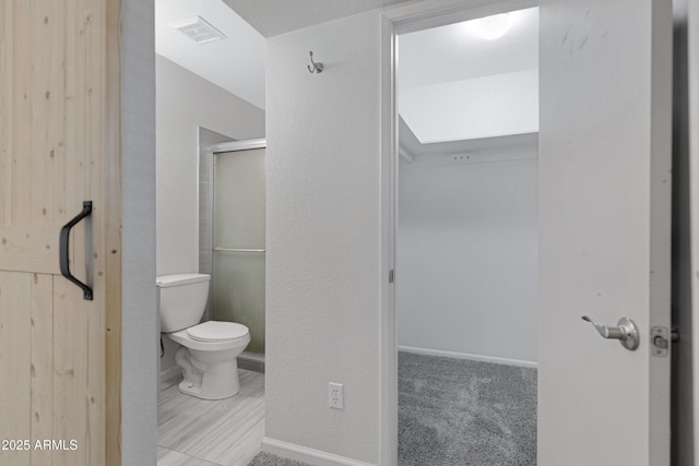 bathroom with toilet and an enclosed shower