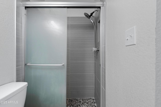 bathroom with walk in shower and toilet