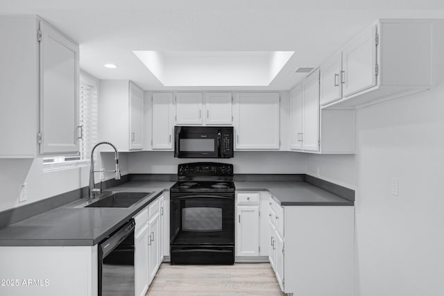 kitchen featuring sink, white cabinets, light wood-type flooring, and black appliances