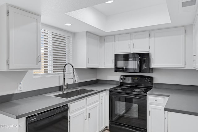 kitchen featuring white cabinets, a raised ceiling, black appliances, and sink