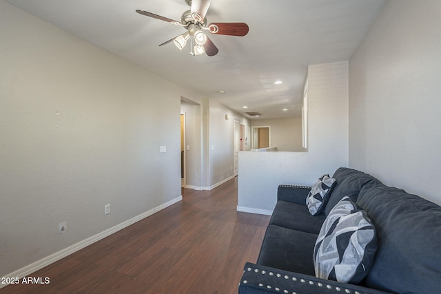 living room featuring ceiling fan and dark hardwood / wood-style flooring