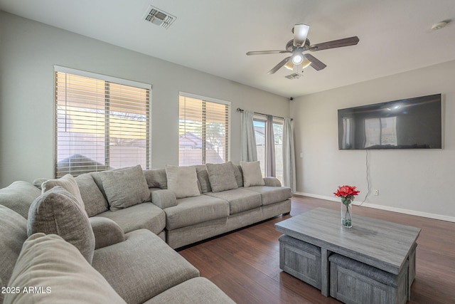 living room featuring dark wood-type flooring and ceiling fan