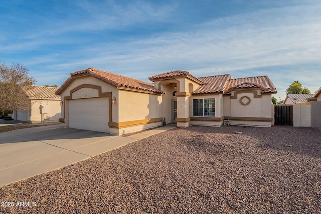 mediterranean / spanish home with a garage, a tile roof, driveway, and stucco siding