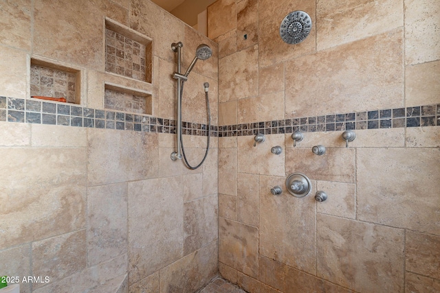 interior details with a tile shower