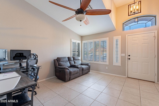 office space featuring high vaulted ceiling, ceiling fan with notable chandelier, baseboards, and light tile patterned floors