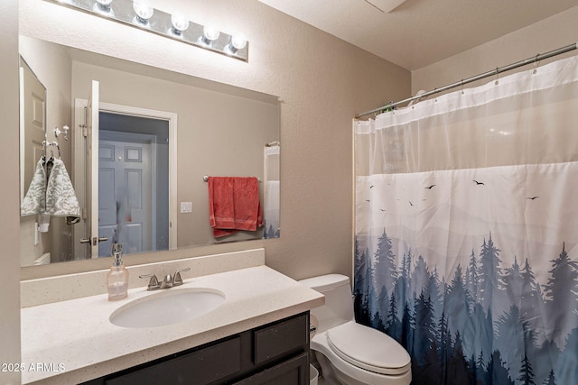 full bath with a shower with curtain, a textured wall, vanity, and toilet