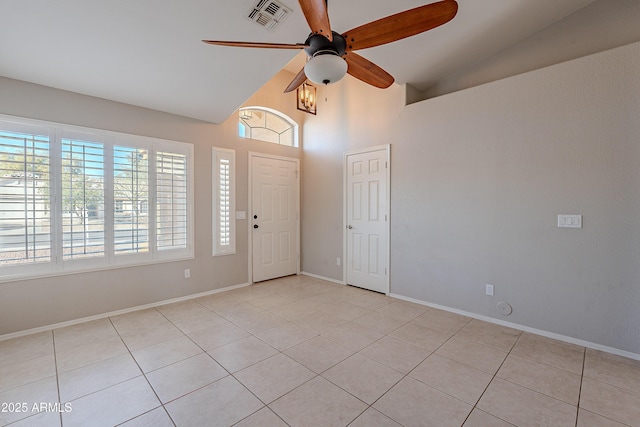 empty room featuring ceiling fan, high vaulted ceiling, light tile patterned floors, visible vents, and baseboards