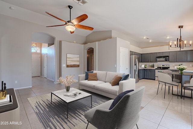 living room with arched walkways, light tile patterned floors, lofted ceiling, visible vents, and ceiling fan with notable chandelier