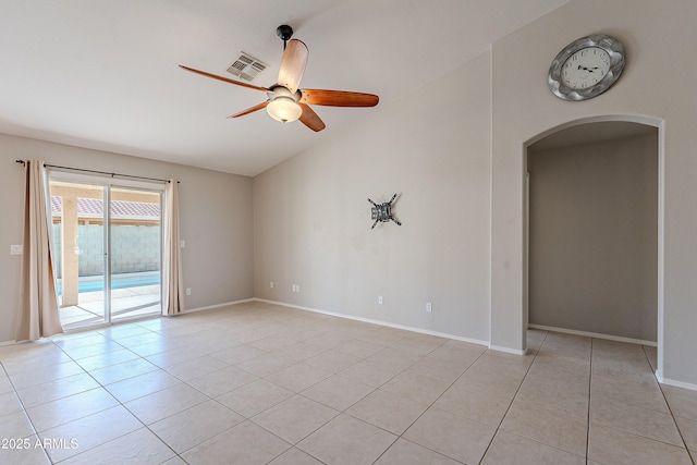 empty room featuring arched walkways, light tile patterned flooring, visible vents, a ceiling fan, and vaulted ceiling