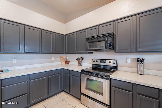 kitchen featuring light tile patterned floors, gray cabinets, light countertops, black microwave, and stainless steel electric range