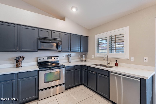 kitchen with light tile patterned floors, appliances with stainless steel finishes, vaulted ceiling, light countertops, and a sink