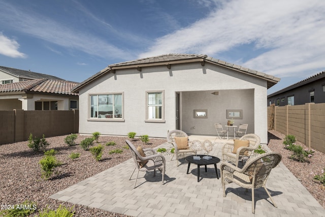 back of property featuring outdoor lounge area and a patio