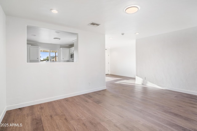 unfurnished room featuring visible vents, recessed lighting, baseboards, and wood finished floors