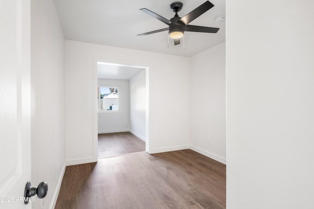 spare room featuring a ceiling fan, baseboards, and wood finished floors