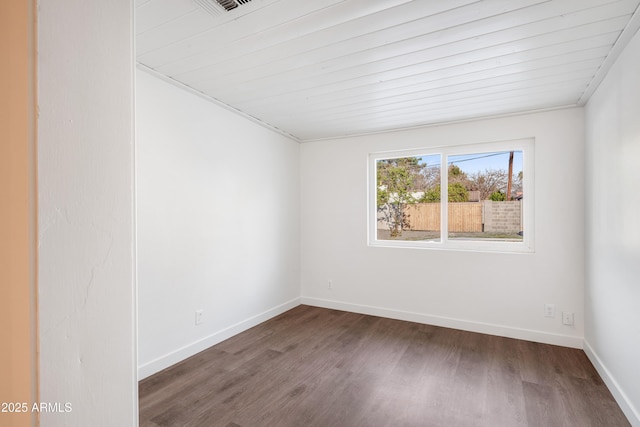 spare room featuring wood finished floors and baseboards