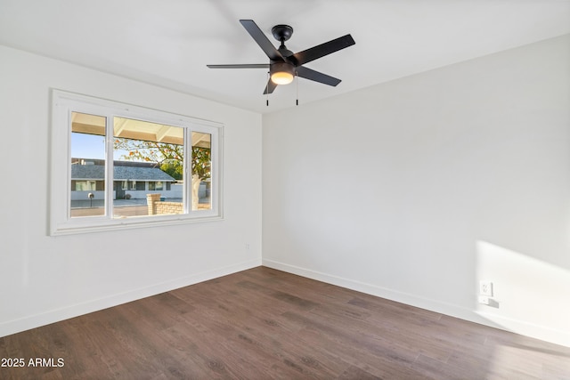 spare room with baseboards, dark wood-type flooring, and ceiling fan