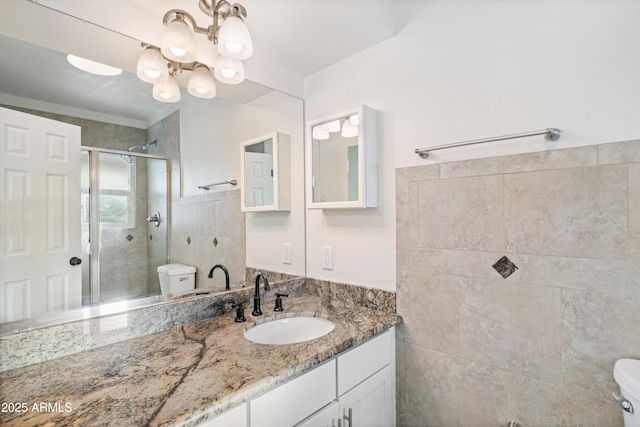 full bathroom with a notable chandelier, vanity, toilet, and a shower stall