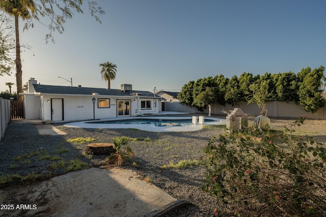 back of house featuring a patio, a fenced backyard, a fenced in pool, and central AC