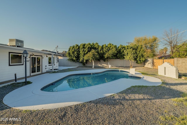 view of pool with a fenced backyard, a fenced in pool, and central AC