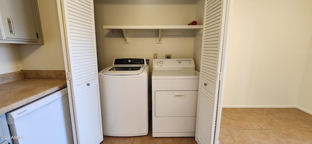 clothes washing area featuring separate washer and dryer and light tile patterned floors