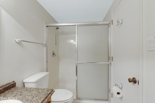 bathroom featuring vanity, an enclosed shower, and toilet