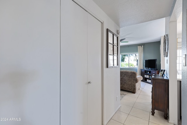 hallway with light tile patterned floors and a textured ceiling