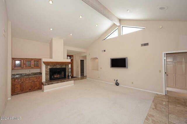 living room with high vaulted ceiling, a high end fireplace, and beamed ceiling