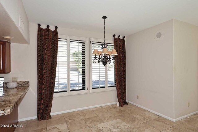 unfurnished dining area with a chandelier