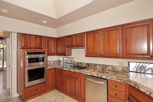 kitchen featuring double oven, sink, vaulted ceiling, and black electric stovetop