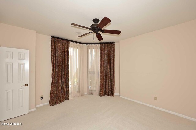 spare room with light carpet and ceiling fan