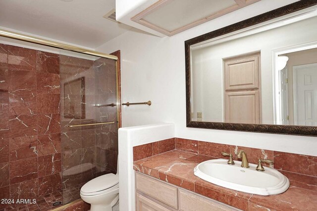 bathroom with vanity, an enclosed shower, and toilet