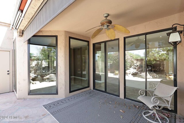 view of exterior entry featuring a patio and ceiling fan