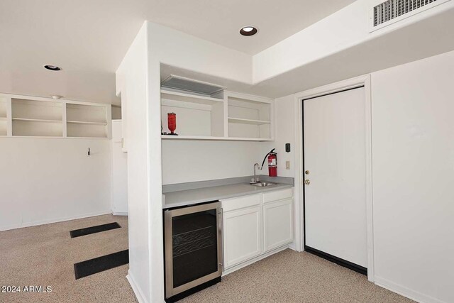 bar with wine cooler and white cabinetry