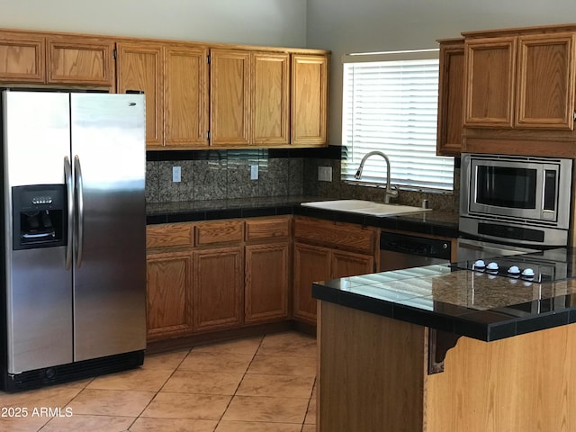 1502 E Estrid Ave, Phoenix, AZ 85022 - kitchen featuring appliances with stainless steel finishes, a peninsula, tasteful backsplash, a kitchen breakfast bar, and light tile patterned floors