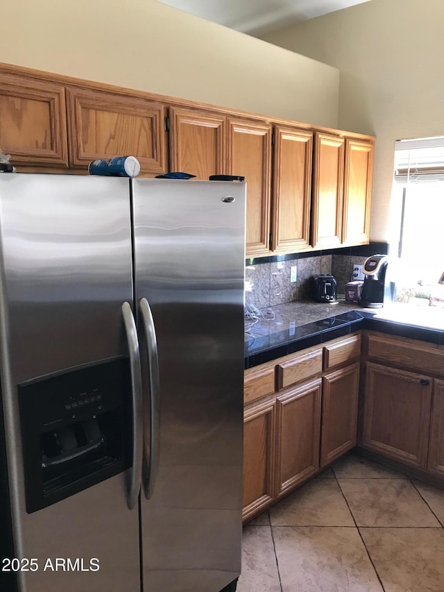 1502 E Estrid Ave, Phoenix, AZ 85022 - kitchen with stainless steel fridge, light tile patterned floors, tasteful backsplash, and brown cabinetry