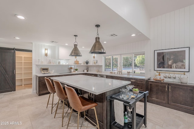 2724 W Colt Rd, Chandler, AZ 85224 - kitchen with open shelves, a barn door, a kitchen bar, dark brown cabinets, and recessed lighting