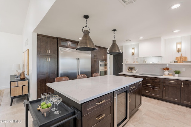 2724 W Colt Rd, Chandler, AZ 85224 - kitchen with stainless steel appliances, beverage cooler, dark brown cabinets, a center island, and recessed lighting